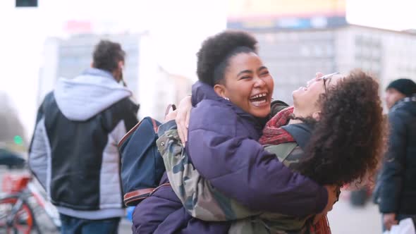Two young multiethnic women outdoor hugging laughing