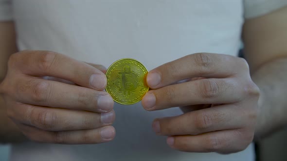 Man Holding Bitcoin Coin in His Hands