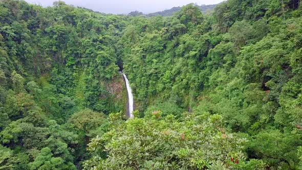 Flying through the Costa Rica rainforest with La Fortuna Waterfall in background