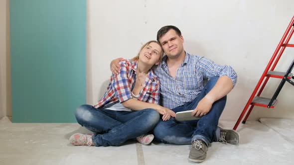  Footage of Happy Young Couple Sitting and Relaxing on Floor of Their New House Under Renovation