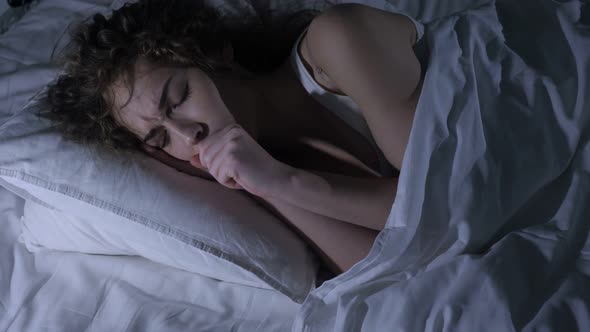 Coughing Sick Female Lying in Dark Bedroom at Night