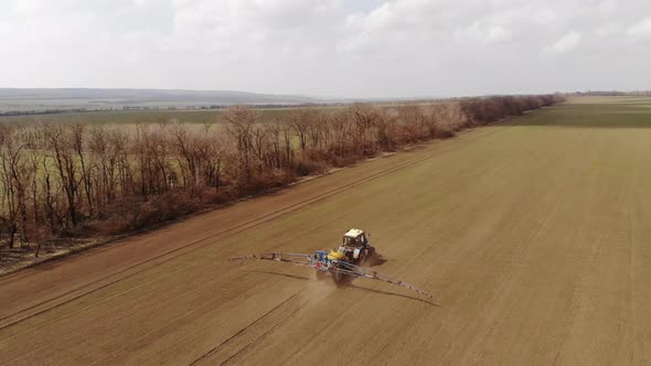 Aerial View Agricultural Machinery Spraying Insecticides on a Plowed Field