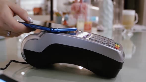 Woman Paying Through Smart Phone Using NFC