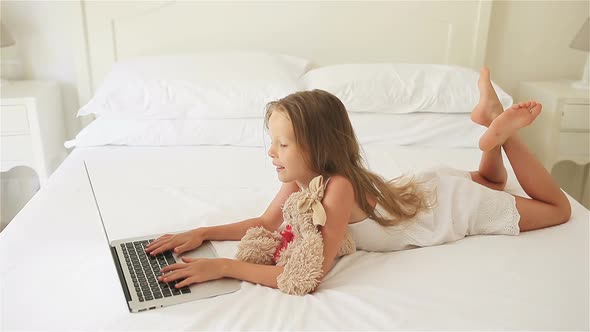 Cute Little Girl Doing Homework on Laptop