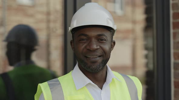 Portrait of Happy Foreman in Helmet Posing at Building Site