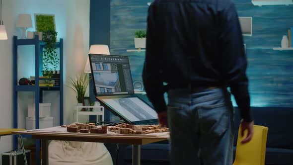 Man Architect Using Touch Screen Monitor with Building Model