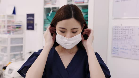 Portrait of beautiful young woman female doctor wearing medical face mask indoors in office.