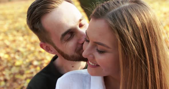 Close View of Happy Man Kisses His Lovely Girl in Embraces They Smile in Park