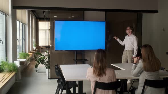 Diverse office conference room meeting male project manager uses Chroma Key wall mounted blue screen