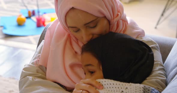 Mother and embracing each other in living room