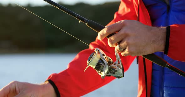 Man tying bait in fishing rod on motorboat 4k