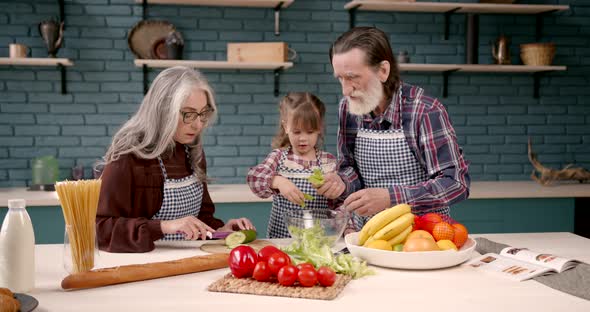 Senior Grandparents Couple with Granddaughter Cooking in Kitchen