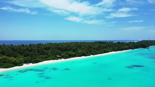 Natural fly over tourism shot of a sandy white paradise beach and blue water background in vibrant 4