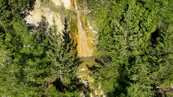 A small waterfall in the mountains aerial view 4 K