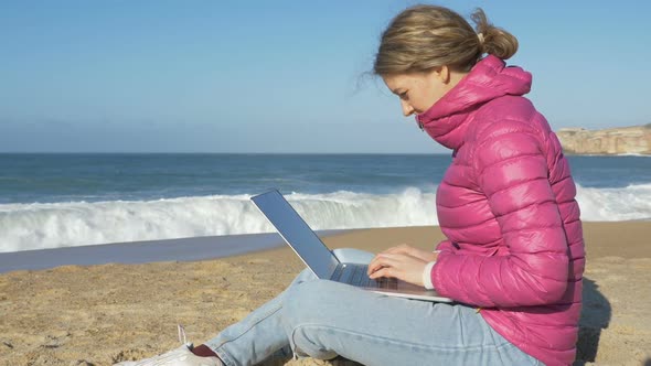 Lady Sits with Laptop on Beach Sand Works Surfing Internet