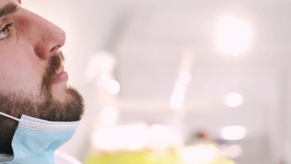 A Nurse in Gloves Taking Nasal Swab From Young Man in Mask