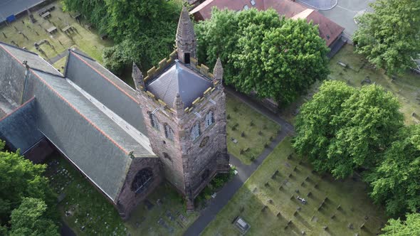 Aerial view above rural English town woodland countryside idyllic church rooftop and graveyard alt