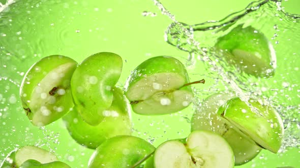 Super Slow Motion Shot of Flying Fresh Apple Slices and Water Side Splash at 1000 Fps