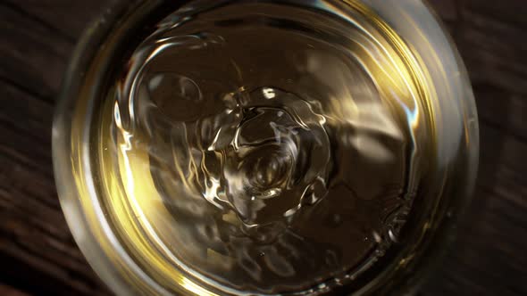 Super Slow Motion Macro Shot of Dripping Droplet Into Filled Glass of White Wine at 1000Fps