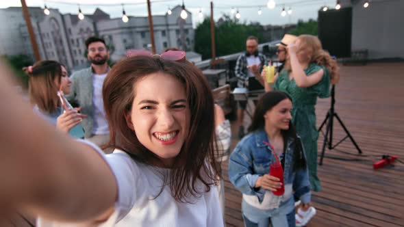 Woman Blogger Vlogger Shooting POV Selfie Video Photo at Roof Party Smiling Dancing with Friends