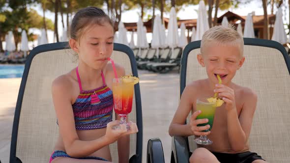 Portrait of Cheerful Children Near the Pool with Bright Rainbow Cocktails