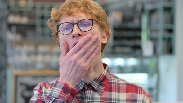 Close Up of Sleepy Young Redhead Man Yawning