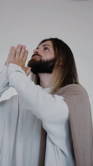 Jesus Prays with His Hands Together on a White Background alt