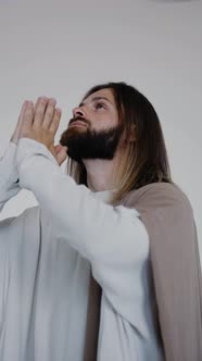 Jesus Prays with His Hands Together on a White Background