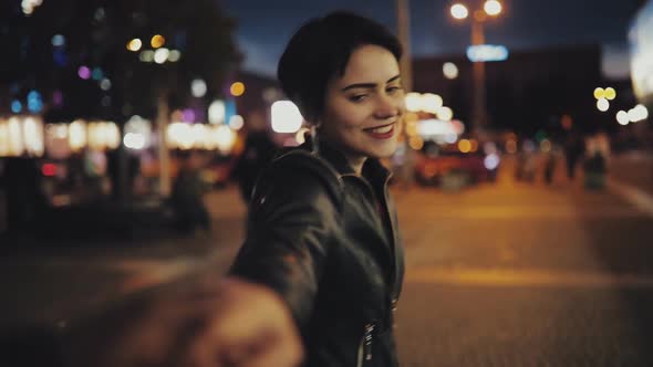 Slowmotion of Woman Follow Me Holding Male Hand Looking To Camera at Night Time