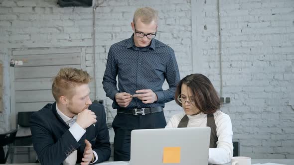 Businessman and Mature Woman Sitting in Office with Modern Inter