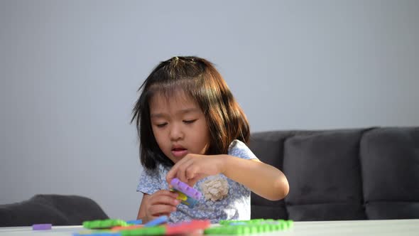 Cute Asian little girl playing with colorful toy ABC jigsaw, Kids play with educational toys at kind alt