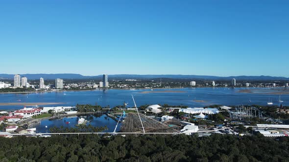 Unique view of a wooden rollercoaster being constructed close to a coastal waterway with a mountain