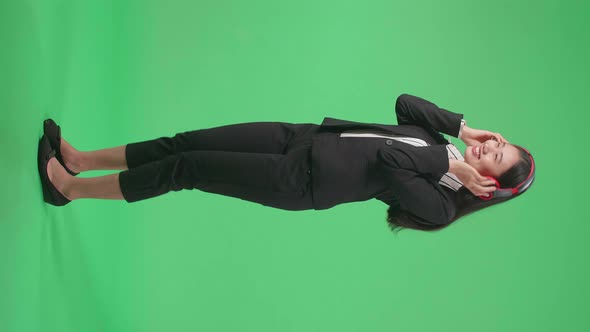 Full Side View Body Of Asian Business Woman Listening To Music And Dancing On Green Screen Studio