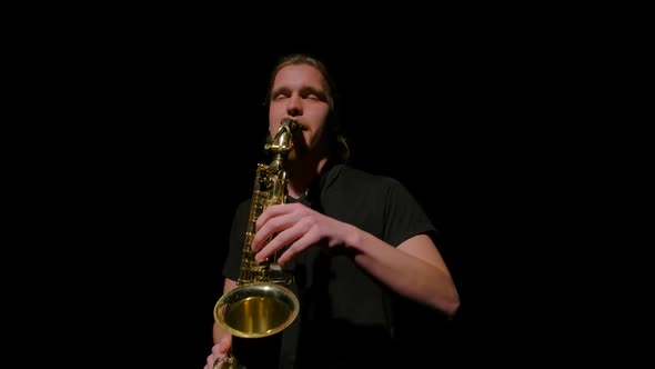 Orbital Shot of a Saxophonist Playing a Golden Wind Instrument in the Dark