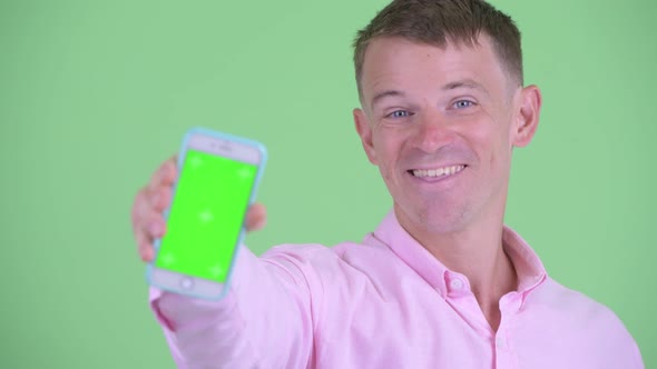 Face of Happy Businessman Showing Phone