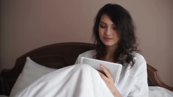 Young Beautiful Women Looking a Tablet on Bed Acting Confuse