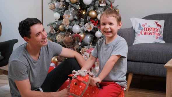 Little Boy Having Fun with Father Near Xmas Tree