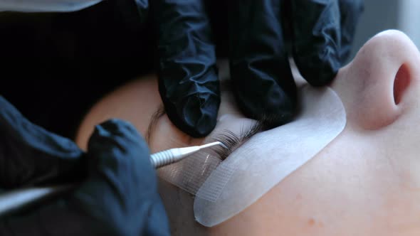 Beautician Separates the Lashes with a Needle and Bends Them Into Curlers. Lash Lamination