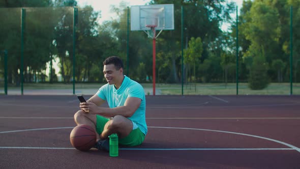 Basketball Player Networking with Phone on Court