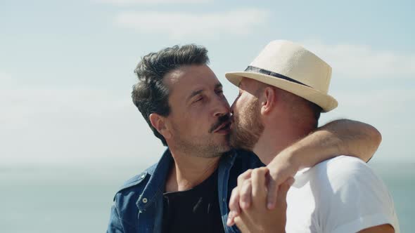 Medium Shot of Gay Couple Kissing Outdoors in Windy Weather