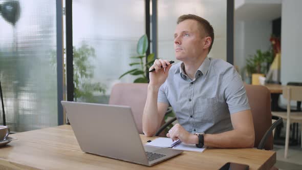 Young Thoughtful Business Man Thinking of Problem Solution Working on Laptop