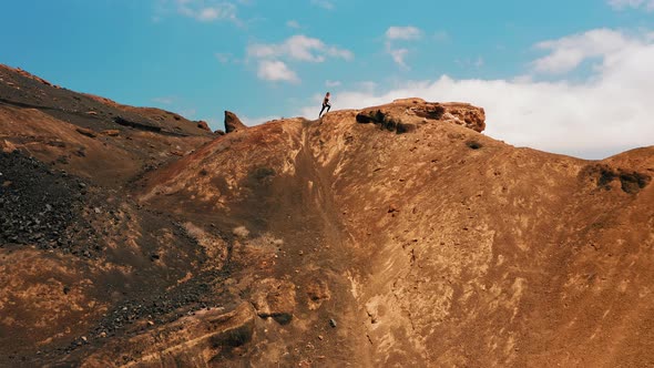 Woman in Sportswear Walks Along the Endless Desert Sandy Hills