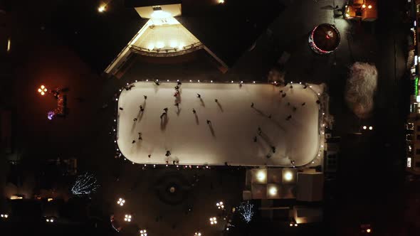 People Are Skating on Ice Rink in the Evening, Aerial Vertical Top-down View