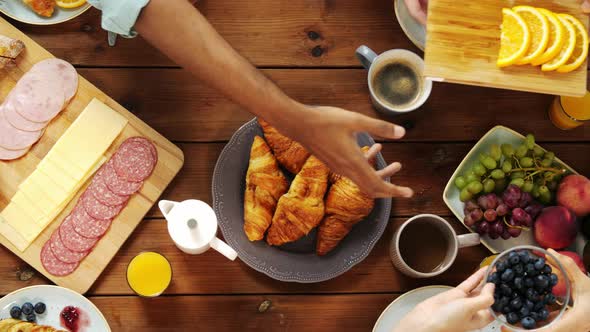 Group of People Eating at Table with Food 