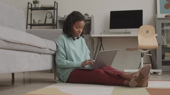 Beautiful African Teenage Girl Using Laptop Indoors