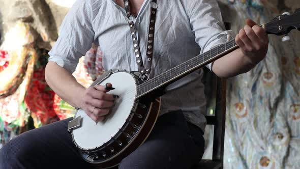 Male Musician Playing Banjo Sitting Chair Indoor