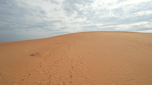 low aerial flying above the top of a desert sand dune in Mui Ne Vietnam