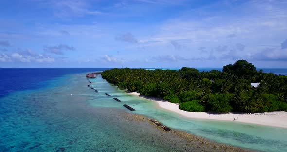 Luxury drone copy space shot of a sandy white paradise beach and blue ocean background in vibrant 4K