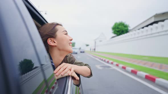 Asian beautiful woman traveler open car window to face air outside