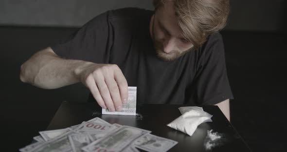 Young Addicted Man Taking Cocaine with Dollar